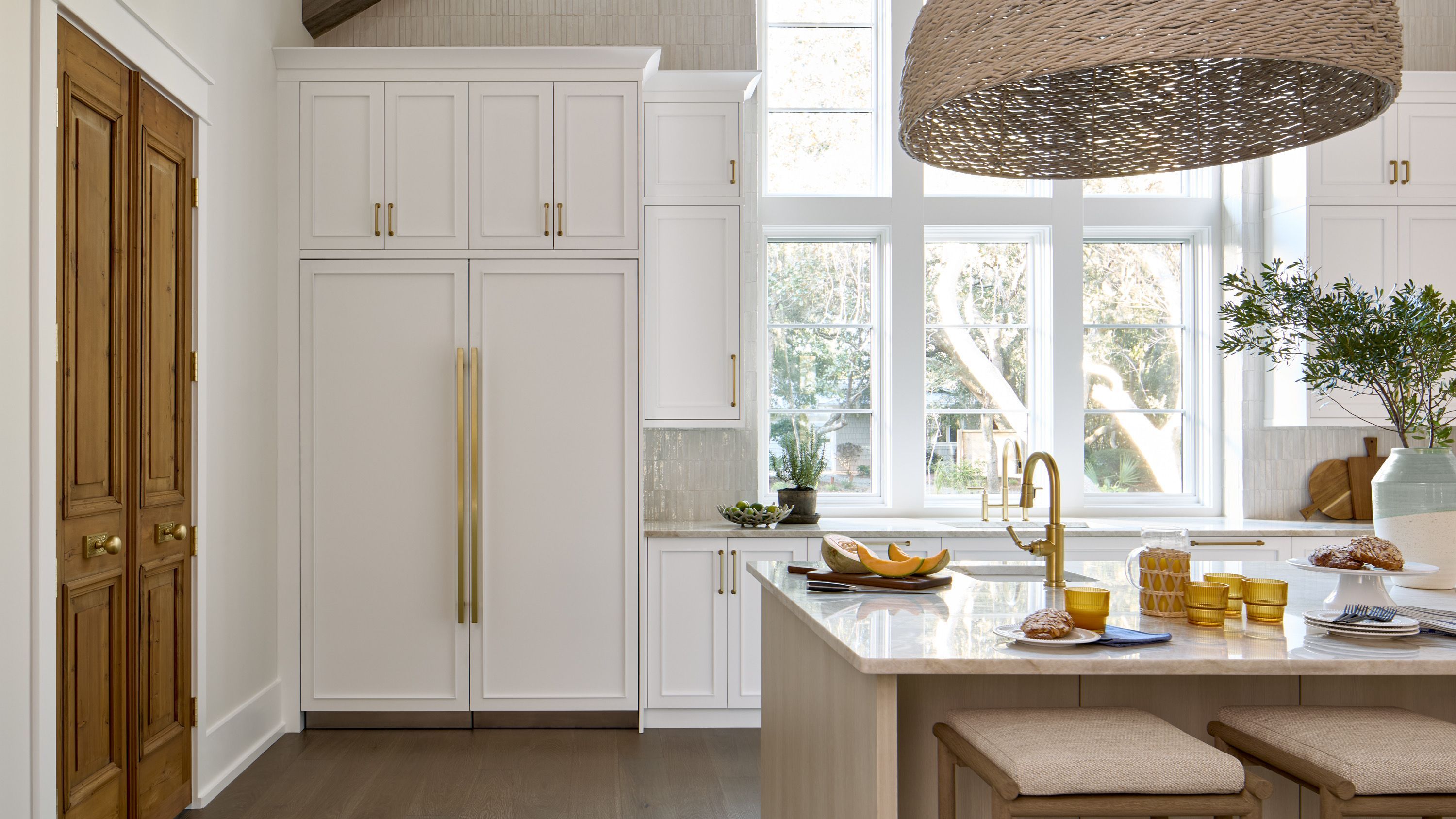 Dark kitchen with a vertical line of light from a Viking Integrated Refrigerator door slightly ajar
